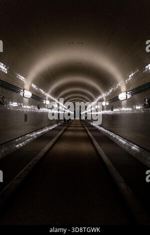 Blick auf Menschen, die im Alten Elbtunnel in Hamburg am 18. Juni 2025 spazieren. Die Szene fängt den historischen Tunnel mit seinen Charakteristika ein Stockfoto
