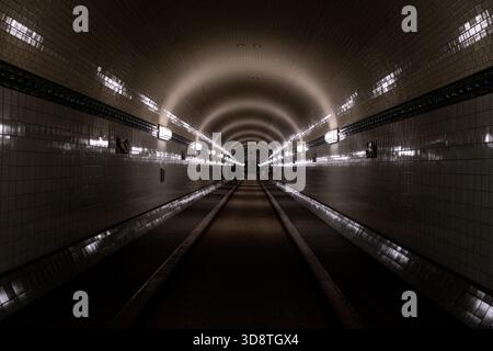 Blick auf Menschen, die im Alten Elbtunnel in Hamburg am 18. Juni 2025 spazieren. Die Szene fängt den historischen Tunnel mit seinen Charakteristika ein Stockfoto