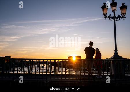 Ein Paar stand am 13. Juli 2023 auf der Pont Saint Pierre Brücke bei Sonnenuntergang über dem Fluss Garonne in Toulouse in Occitanie in Frankreich. Die Szene fängt einen roma ein Stockfoto