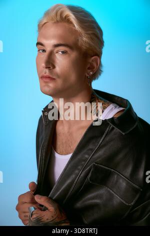 Ein junger Mann mit auffälligen Details zeigt moderne Mode und posiert selbstbewusst. Stockfoto