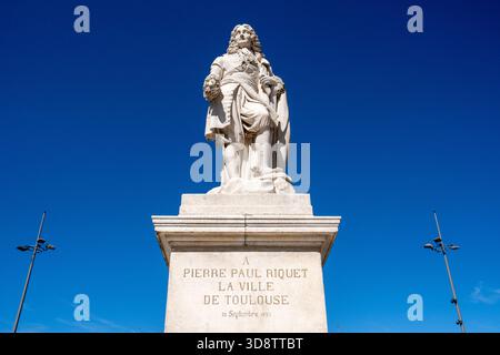 Statue von Pierre Paul Riquet auf einem Sockel mit Inschrift, die der Stadt Toulouse unter klarem blauem Himmel in Toulouse in Haute-Garonne im Oktober gewidmet ist Stockfoto