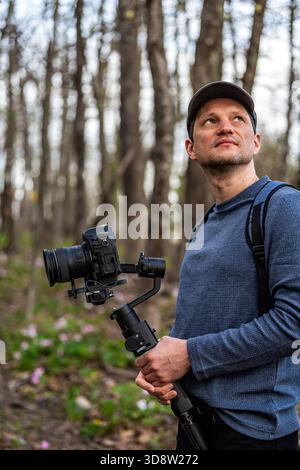Mann Fotograf mit Kamera Gimbal für rosa Trillium Wildblumen Feld in Virginia Blue Ridge im Wintergreen Resort Stockfoto
