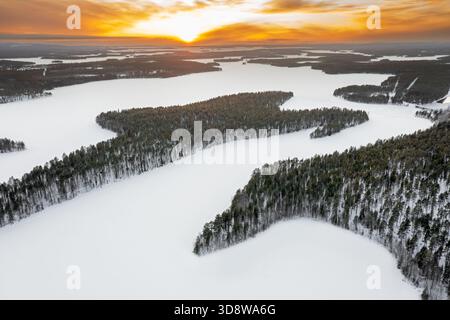 Blick aus der Vogelperspektive über Wald und schneebedeckten gefrorenen Lahnaselkä See in Kuusamo im Winter, Koillismaa, nördliche Ostrobothnia Region, Finnland, Skandinavien Stockfoto