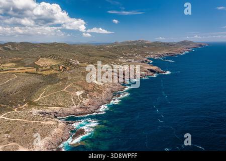 Eine atemberaubende Luftszene mit zerklüfteter Küste, tiefblauem Ozean und sanften Hügeln mit verstreuten Gebäuden, Sardinien, Italien Stockfoto