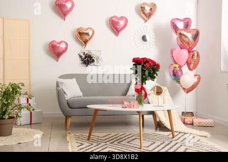 Das Innere des festlichen Wohnzimmers ist mit Ballons in Herzform und Rosenstrauß zum Valentinstag dekoriert Stockfoto