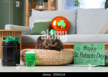 Niedliche Katze im Kobold Hut mit einem Becher grünes Bier und festlicher Postkarte für die Feier zum St. Patrick's Day zu Hause Stockfoto
