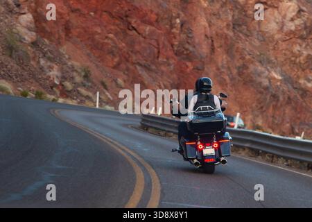 Biker-Paar, das mit dem Hubschrauber durch die Bergstraße fährt. Ausgerüstete Motorradfahrer, die auf kurvenreichen Bergstrecken unterwegs sind. Zwei Motorradfahrer fahren mit dem Chopper durch den Bergpass. Rückansicht, Nahaufnahme Stockfoto
