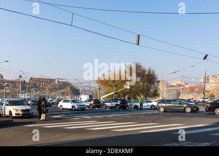 Jerewan Armenien 10.25.2025. Eine geschäftige Kreuzung mit Autos und Fußgängern. Die Szene ist voll und geschäftig. Die Straße ist voll mit Autos und Menschen, und Stockfoto