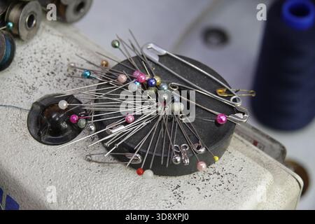 Little India, Singapur, 9. September, 2025 verschiedene Nadeln erwarten ihren Handwerker auf einer Nähmaschine in einer Bekleidungswerkstatt auf dem Bürgersteig Stockfoto