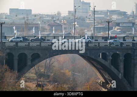 Jerewan Armenien 10.25.2025. Eine Brücke pobeda überspannt einen Fluss mit Autos und Vögeln im Hintergrund. Die Szene ist ruhig und ruhig, mit dem Stockfoto