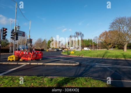 Ampeln an einem Kreisverkehr mit Baustellen an einem hellen, sonnigen Wintertag mit klarem blauem Himmel Stockfoto