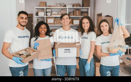 Gruppe von Freiwilligen, die gemeinsam Lebensmittelspenden für lokale Gemeindeunterstützung sammeln Stockfoto