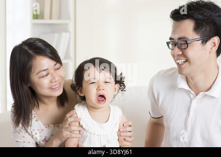 Eltern trösten ihre weinende Tochter. Asiatische Familie zu Hause Stockfoto