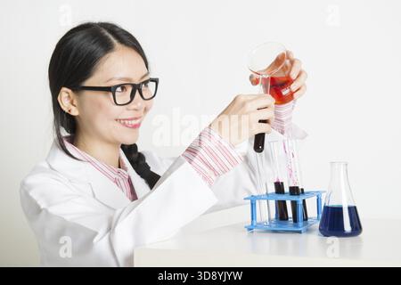Porträt von smart und junge asiatische Wissenschaftler machen Experiment im Labor mit Chemieflüssigkeit Stockfoto