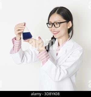 Porträt junger asiatischer Wissenschaftlerinnen, die im Labor Experimente mit Chemieflüssigkeit machen Stockfoto
