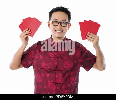 Asiatische chinesische Mann halten rote Pakete / Ang pow für frohes neues Jahr, isoliert auf weißem Hintergrund Stockfoto