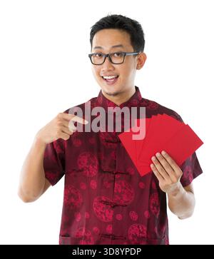 Südostasiatischer chinesischer Mann in Cheongsam-Händen, der rote Pakete / ang Pow hält, isoliert auf weißem Hintergrund Stockfoto