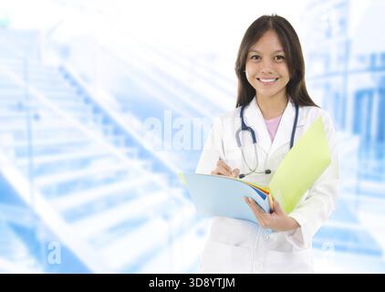 Südostasiatischer Medizinstudent. Junge Ärztin, die auf Krankenhaushintergrund steht Stockfoto