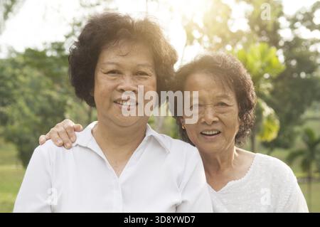Porträt der gesunden glücklichen asiatischen Senioren Mutter und Tochter im Outdoor-Naturpark, Morgen schöne Sonnenlicht Hintergrund Stockfoto