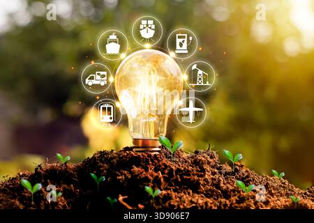 Eine leuchtende Glühbirne aus dem Boden mit Energie- und Verkehrssymbolen symbolisiert saubere Energie, ökologische Innovation, grüne Technologie und nachhaltige Zukunft Stockfoto