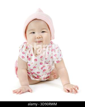 Porträt des glücklichen asiatischen Mädchens in rosa Kleidung, das auf dem Boden kriecht, isoliert auf weißem Hintergrund Stockfoto