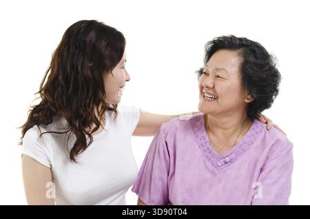 Porträt einer asiatischen älteren Mutter und einer erwachsenen Tochter, die sich gegenseitig anschauen, isoliert auf weißem Hintergrund Stockfoto