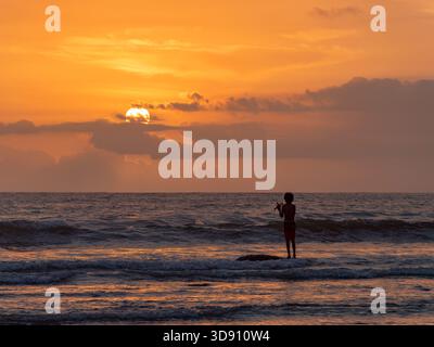 Bali, Indonesien - 23. Oktober 2017: Einheimischer Fischer bei Sonnenuntergang am Strand in Medewi auf der indonesischen Insel Bali. Stockfoto