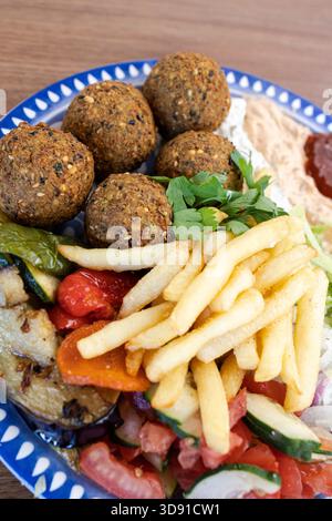 Köstliche Falafel-Mahlzeit aus dem Nahen Osten mit Kichererbsen, gegrilltem Gemüse und frischem Salat Stockfoto