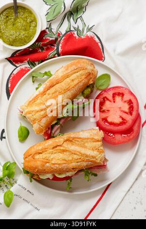 Baguette-Sandwich mit Pesto, Schinken, Tomaten, Burrata und Rucola.Top view.selective Fokus Stockfoto