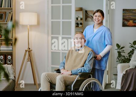 Porträt eines Seniorenmannes mit Behinderung, der mit einer jungen Erwachsenen-Schwester sitzt Stockfoto