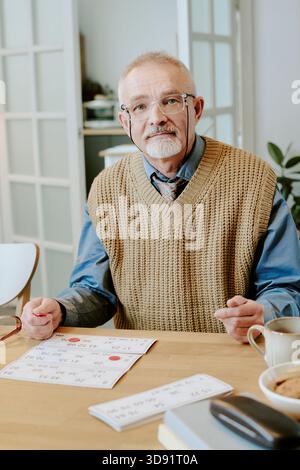 Porträt eines Seniorenmannes, der am Tisch sitzt und den Kalender überprüft Stockfoto