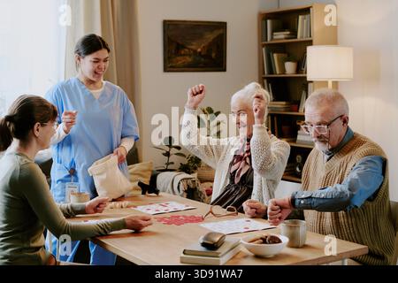 Seniorin feiert Bingo Win mit Schwester und älteren Freunden Stockfoto