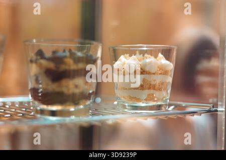Elegante Nahaufnahme eines mehrschichtigen Napoleons (Mille-feuille), serviert in einem Glas – cremiger Pudding, knuspriger Blätterteig und Puderzucker. Stockfoto