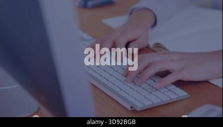 Tippfrau mit weißer Manschette am Schreibtisch, mit schlanker weißer Tastatur, Papieren, silbernem Monitor Stockfoto