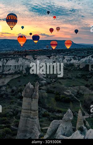 Der Blick auf Heißluftballons gleitet ruhig über die Landschaft aus der anderen Welt, deren leuchtende Farben sich mit den sanften Tönen des Sonnenaufgangs, Love Valley, CA, abheben Stockfoto
