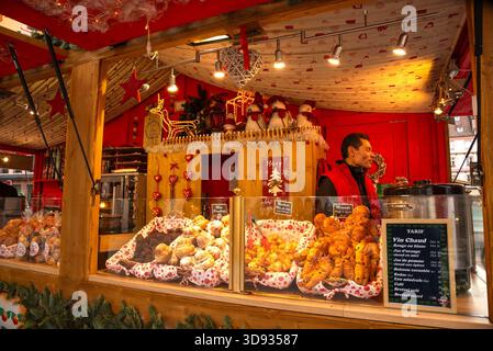 Straßburg, Frankreich - 24. Dezember 2022: Traditionelle elsässische Kekse und heißer Wein zum Verkauf in einer Bäckerei auf dem Weihnachtsmarkt. Stockfoto
