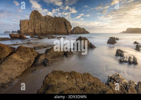 Sonnenaufgang über dem Strand an Playa de la Arnia an der Costa Quebrada, Kantabrien, Spanien. Herbst (September) 2025. Stockfoto