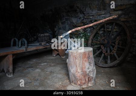 Die Axt des Henkers steckt in einem Stumpf in der Folterkammer Stockfoto