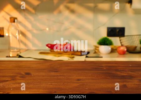 Farbenfrohe Früchte und Gemüse werden auf einer hölzernen Arbeitsplatte in einem hellen Küchenraum platziert Stockfoto
