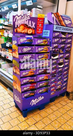 ISERLOHN, DEUTSCHLAND — 27. NOVEMBER 2025: Große Supermarktregale gefüllt mit Milka-Schokoladentafeln im Lidl-Geschäft Stockfoto