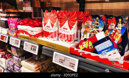 ISERLOHN, DEUTSCHLAND — 27. NOVEMBER 2025: Schokoladenprodukte von Rafaello und Kinder werden heute im Lidl-Supermarkt auf einem Ausstellungsregal aufgestellt Stockfoto
