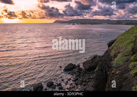 Lombok Indonesia – Bukit Merese fängt Klippen, Meerblick und einen lebhaften Sonnenuntergang an der zerklüfteten Küste ein. Stockfoto