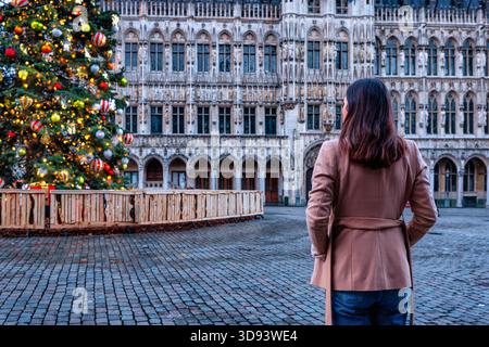 Eine Touristin schaut sich den dekorierten Grande Place in Brüssel, Belgien, zur Weihnachtszeit an Stockfoto