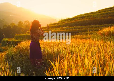 Weicher Fokus auf Fotografin Frau, die Fotos mit spiegelreflexkamera macht professionelle Fotografie auf der Reisterrasse in Sapa, Vietnam Stockfoto