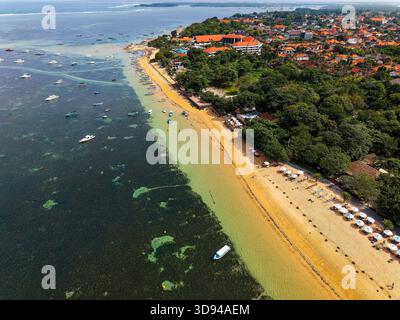 Drohnenblick auf die tropische Küste von Sanur auf Bali mit Booten und Resorts Stockfoto