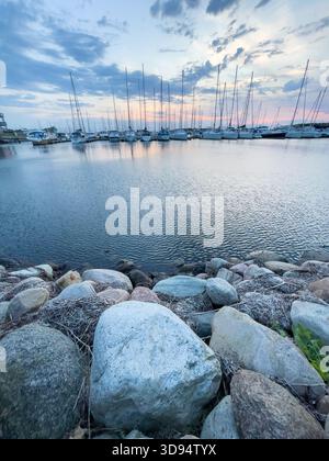 Vertikales Foto von Luxusyachten im dänischen Hirtshals Stadthafen an der Nordsee. Spätsommerabend ruhige Wellen. Stockfoto