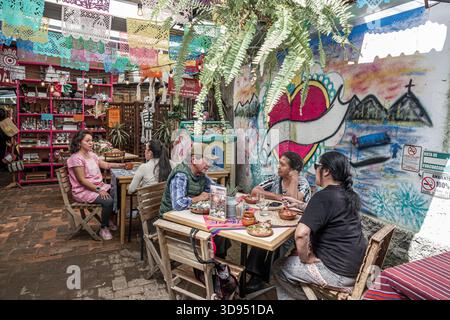 Mexiko-Stadt Mexiko, Xochimilco, Dalia Restaurant Café, Erwachsene Männer Frauen Hispanic Latino Essen Gespräch sitzend, Wand Wandgemälde Herz Kunst Papel Picado über dem Kopf, Stockfoto