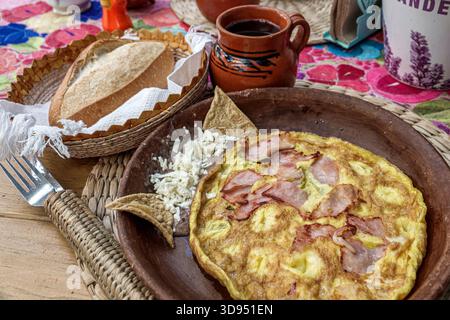 Mexiko-Stadt Mexiko, Xochimilco, Dalia Restaurant Cafe, Nahaufnahme Frühstücksteller, Omelette Schinken Eier, zerbröckelter Käse, Tortilla Chips, handwerklich hergestellter Brotkorb, Lehm m Stockfoto