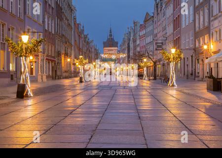 Dekorierte Dluga-Straße mit festlichen Lichtern und historischen Gebäuden in Danzig Polen am Winterabend Stockfoto