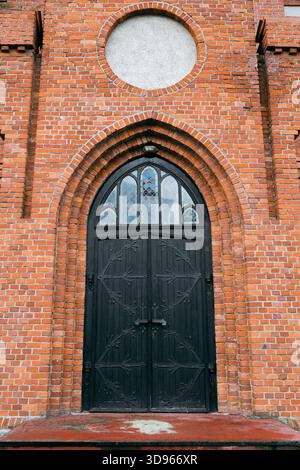 Ein bogenförmiger Eingang zu einer gotischen Kirche. Wunderschöne deutsche gotische Architektur. Stockfoto